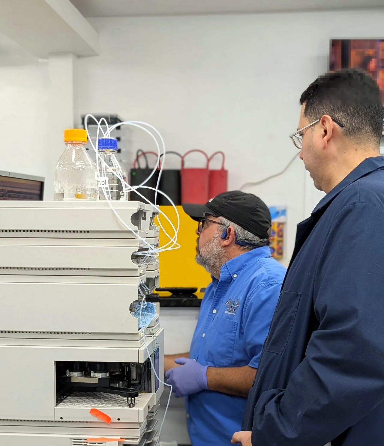 An AMP Tech lab engineer and technician working on an HPLC system together