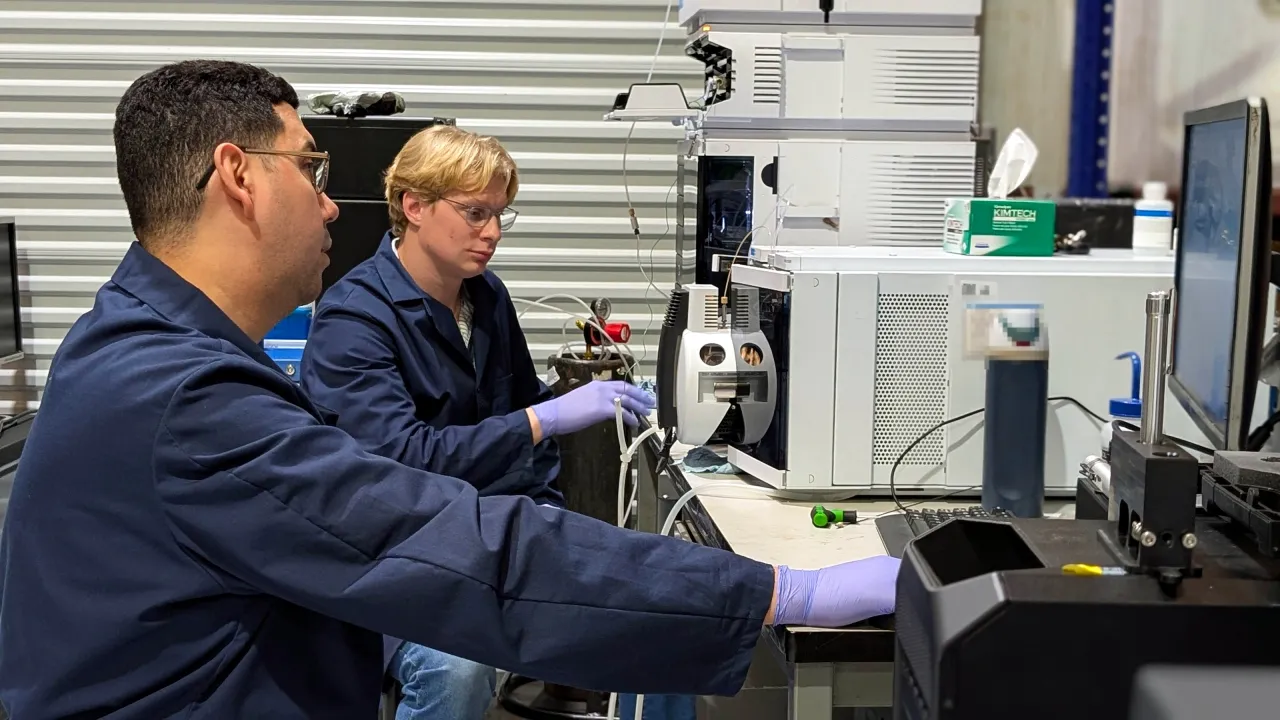 Two AMP Tech technicians testing an LC/MS system at the bench