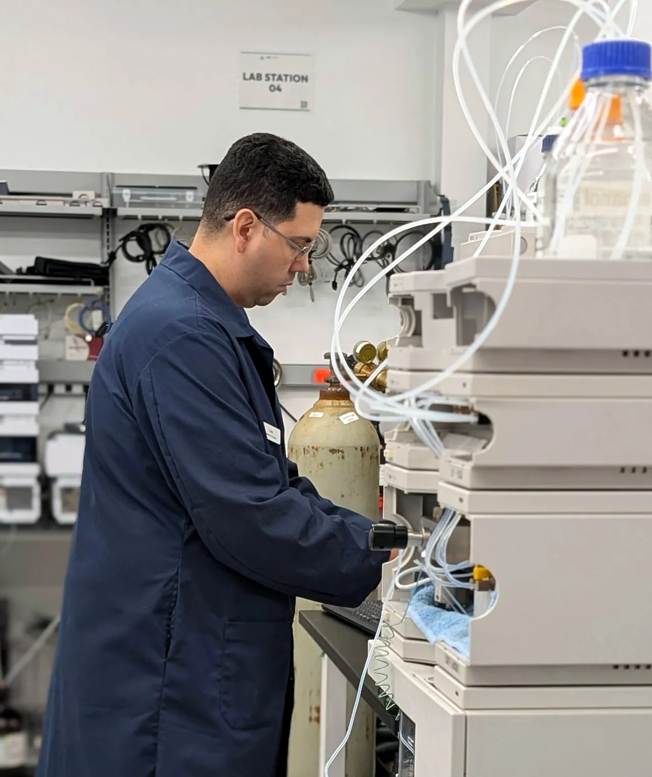 AMP Tech technician working on an HPLC system at a lab station