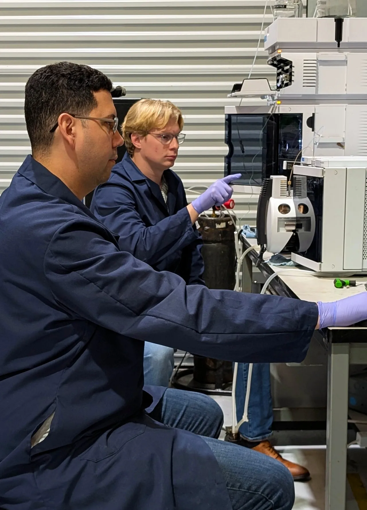 Two AMP Tech technicians working together at an LC/MS bench