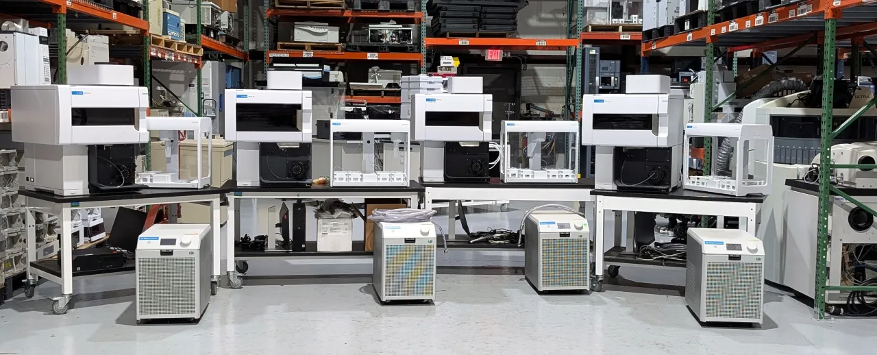 A row of refurbished instruments and chillers staged in AMP Tech's warehouse