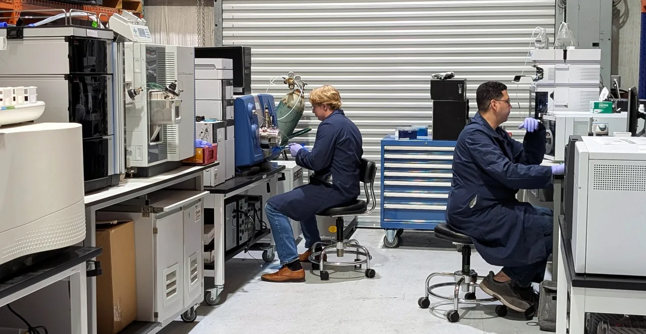 Two AMP Tech lab technicians working at their instrument benches in the Longwood, Florida lab